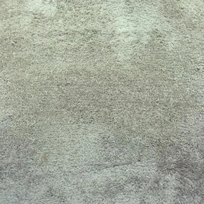 A view looking down at beige carpeted flooring between two white door frames.